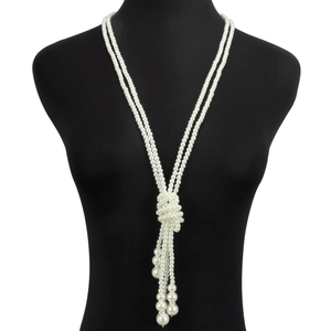 Detail of multilayer long pearl tassel necklace on a black mannequin, vintage style