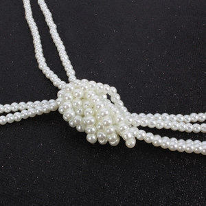 Close-up of elegant multi-layer white pearl necklace with a decorative central knot detail