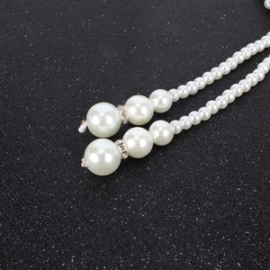 Detailed close-up of multilayer pearls with rhinestone spacers on a black glitter background