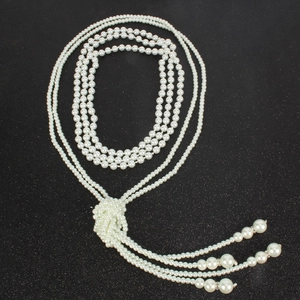 Detail of multi-layer white pearl necklace with vintage silver diamond clasp on black background