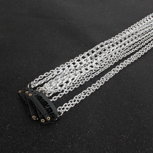 Detail of silver-plated multi-layer tassel hair chains with black BB clip on dark background