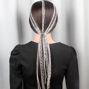 Detail view of silver layered fringe head chain with metallic tassels on long hair