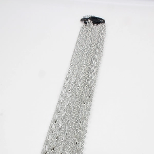 Detail of silver-plated multi-layer chain headwear with black clips on white backdrop