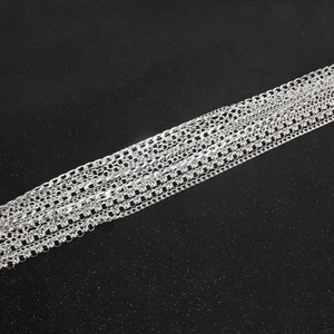 Detail view of various silver-plated tassel chains showing diverse link styles and textures