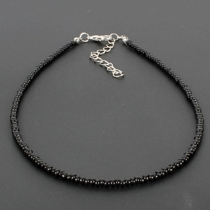 Macro detail of black seed bead choker necklace with silver lobster clasp and extension chain