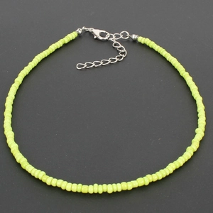 Detail of lime green seed bead choker with adjustable silver lobster clasp on black background