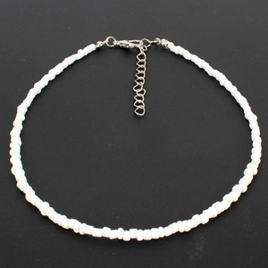 Macro shot of white seed bead choker necklace with a silver lobster clasp and extension