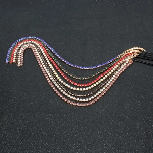 Dettaglio di extension per capelli con nappe in strass arcobaleno e catene colorate