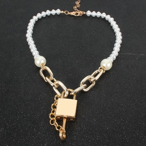 Collar de perlas moderno con colgante de candado y cadena dorada sobre fondo oscuro