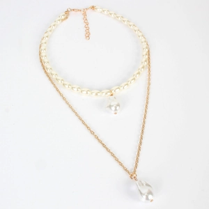 Dettaglio della collana a doppio strato dorata con perle barocche irregolari