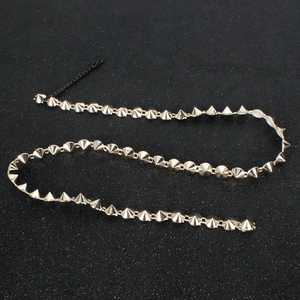 Detail of punk gold conical rivet hair chain with black hair clip for styling