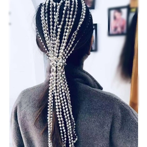 Close-up of silver metal fringe hair chain with spiked studs on dark long hair