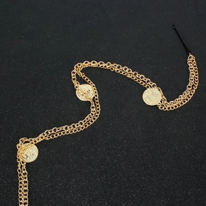 Detail of bohemian layered gold hair chain with embossed coin pendants and elastic band