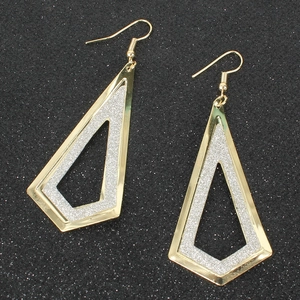 Dettaglio macro di orecchini geometrici in oro e argento glitterati su sfondo nero lucido
