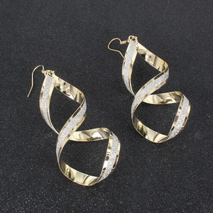 Dettaglio orecchini a spirale dorata con glitter argento e ganci, design geometrico moderno