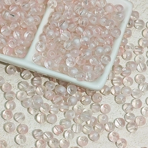 Vue macro de perles de verre translucides rose clair pour la création de bijoux