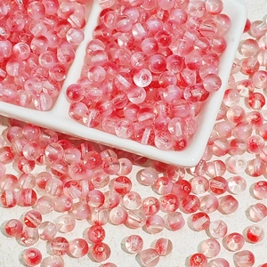 Détail macro de perles en verre rose avec textures givrées rouges pour bijoux DIY
