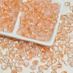 Vue détaillée de perles de verre orange-rose translucides pour bijoux artisanaux