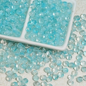 Détail macro de perles en verre bleu clair translucide pour la création de bijoux