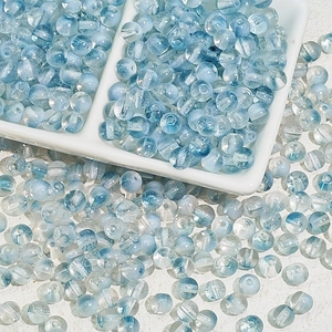 Vue macro de perles en verre translucide bleu clair 8mm avec trou central pour bijoux DIY