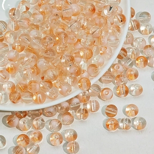 Gros plan de perles en verre orange de 8mm avec paillettes d'or pour bijoux DIY