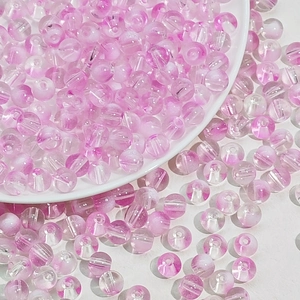 Perles en verre dégradé rose et blanc dans un bol pour création de bijoux DIY
