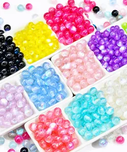 Macro view of colorful translucent resin galaxy beads in a white sorting tray