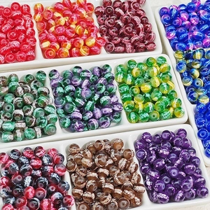 Colorful crackle glass beads in various vibrant colors organized in a white grid tray