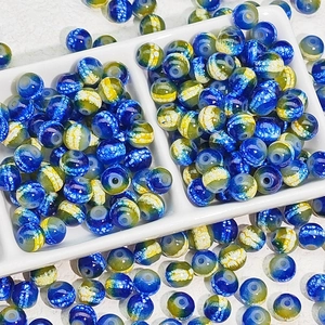 Blue and yellow nebula pattern glass spacer beads for DIY jewelry making in a tray