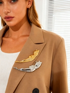 Polished gold and silver minimalist female body sculpture brooches on a blazer lapel