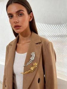 Detailed view of abstract female torso brooches on a camel blazer lapel