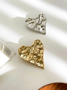 Detail of vintage heart brooches with irregular hammered texture in gold and silver