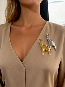 Detailed view of elegant gold and silver elephant brooches with polished mirror finish
