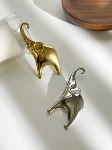 Detailed view of stylized gold and silver elephant brooches with mirror finish