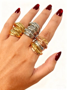 Nahaufnahme von dreifarbigen, breiten Wickelringen in Gold-, Silber- und Roségold-Finish
