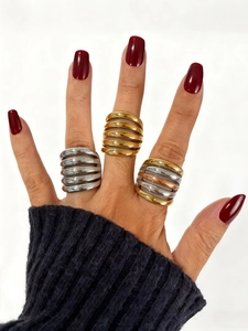 Macro shot of wide ribbed multi-layer metal rings in gold and silver mixed tones