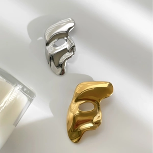 Minimalist vintage mask brooches in gold and silver finish on a clean white background