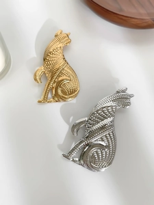 Détail de broches en forme de chat or et argent avec texture tissée complexe