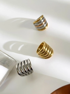 Macro view of wide multi-layered hollow stainless steel rings in gold and silver finishes
