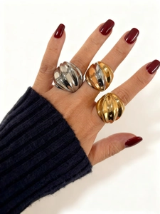 Detalle de tres anillos anchos con textura acanalada en acabados oro, plata y bicolor