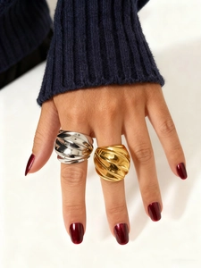 Primer plano de anillos anchos de acero inoxidable en oro y plata con textura de espiral