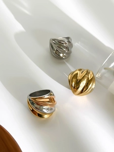 Anillos anchos pulidos con textura ondulada en oro y plata sobre base blanca