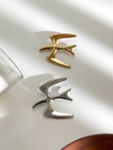 Polished bird brooches in gold and silver finish with elegant shadow backdrop