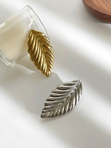 Detail of gold and silver leaf brooches with polished texture and distinct veins