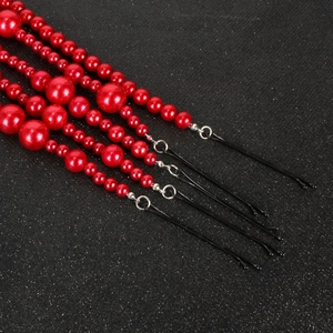 Lot d'épingles à cheveux en perles rouges avec pompons élégants sur fond sombre