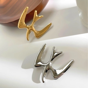 Minimalist geometric bird brooches in gold and silver finish with polished metal texture