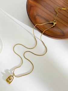 Detail van een 18K vergulde rozenhanger met kristal aan een gladde slangenketting