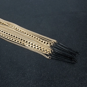 Punk-Stil mehrlagige goldene Metallketten mit schwarzen Haarnadeln auf dunklem Hintergrund