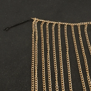 Détail de pinces à cheveux à chaînes dorées avec de longues franges métalliques fluides