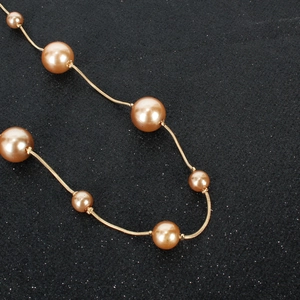 Detailansicht von champagnerfarbenen Perlenhaarschmuck mit goldener Metallkette